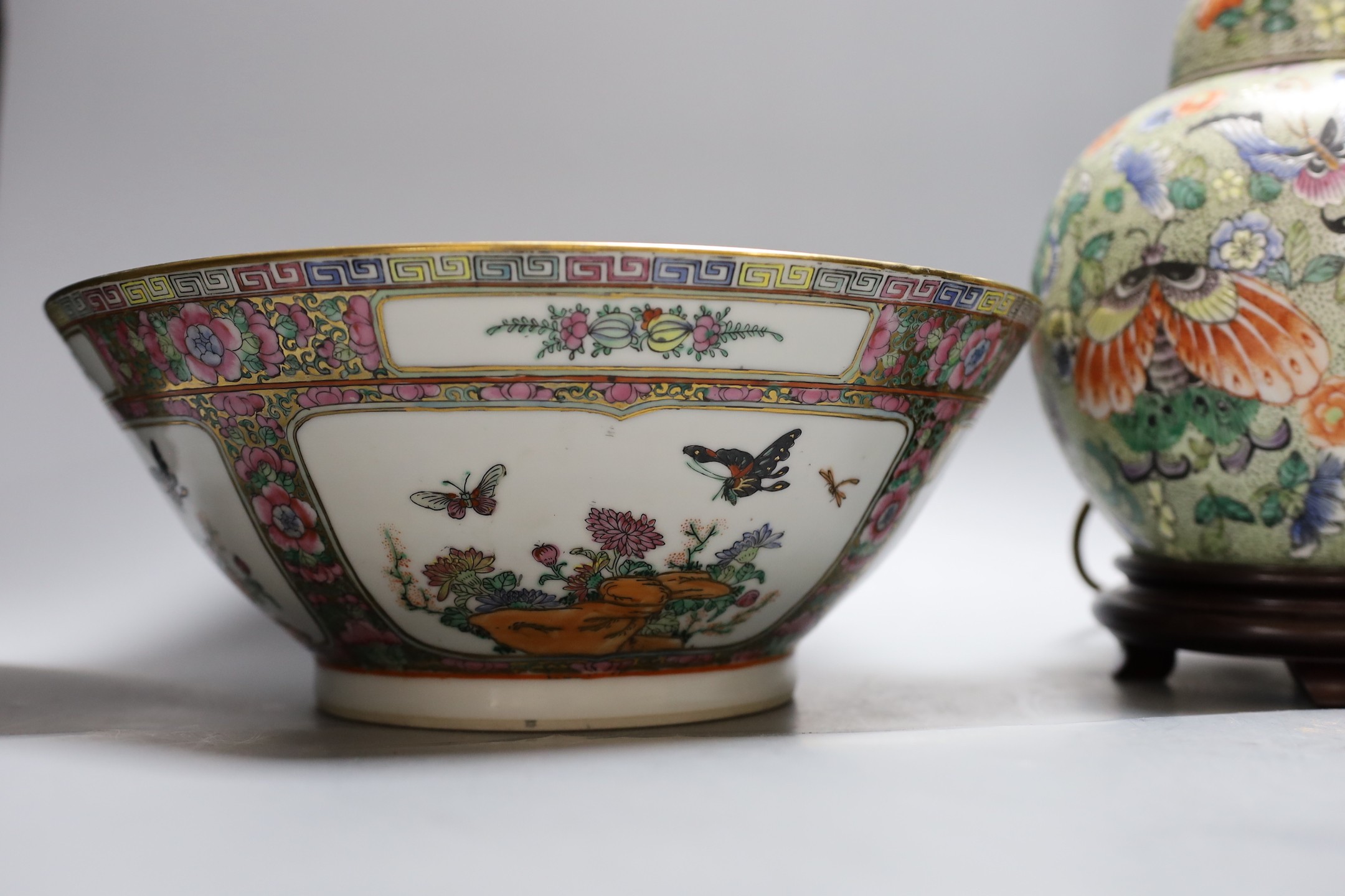 A Chinese famille verte vase converted into a lamp decorated with butterflies amongst botany, together with a famille rose punch bowl with quad-split panel decoration of floral landscapes, 31.5cm diameter